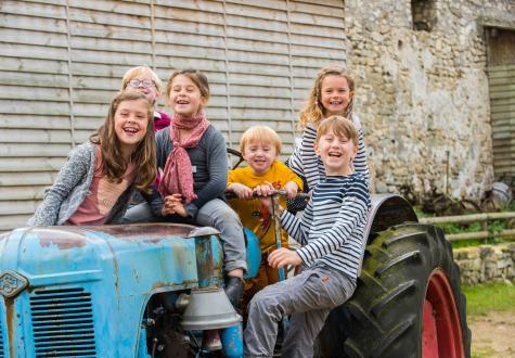 enfants sur le tracteur de la ferme ouverte